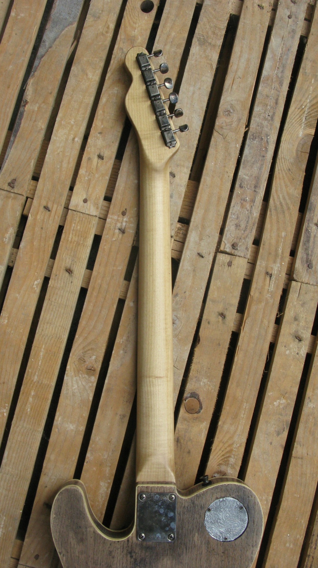 Retro del manico in acero di una chitarra elettrica baritono modello Telecaster con top ricavato da una vecchia cassetta di polvere da sparo