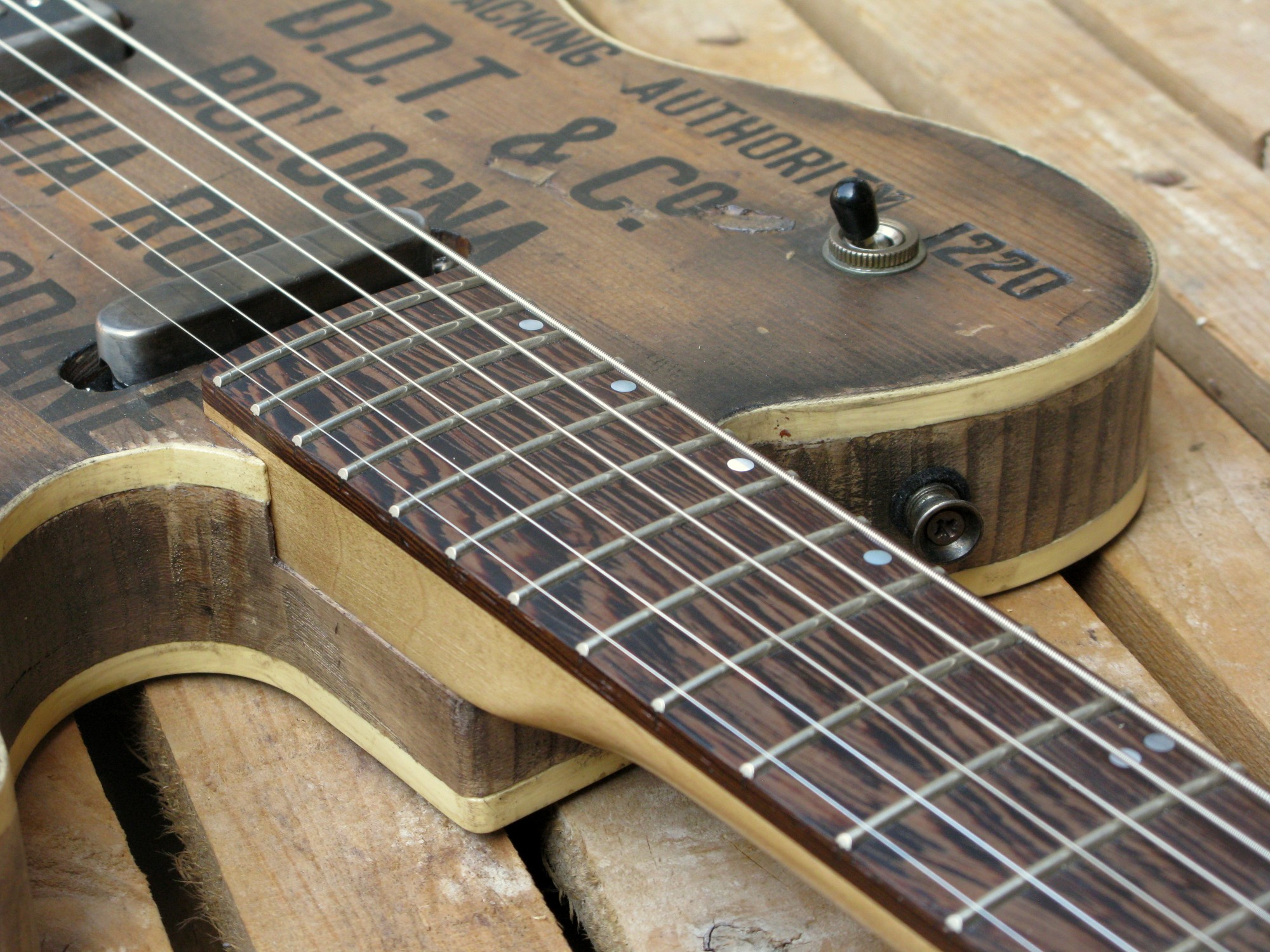 Pickup al manico di una chitarra elettrica baritono modello Telecaster con top ricavato da una vecchia cassetta di polvere da sparo