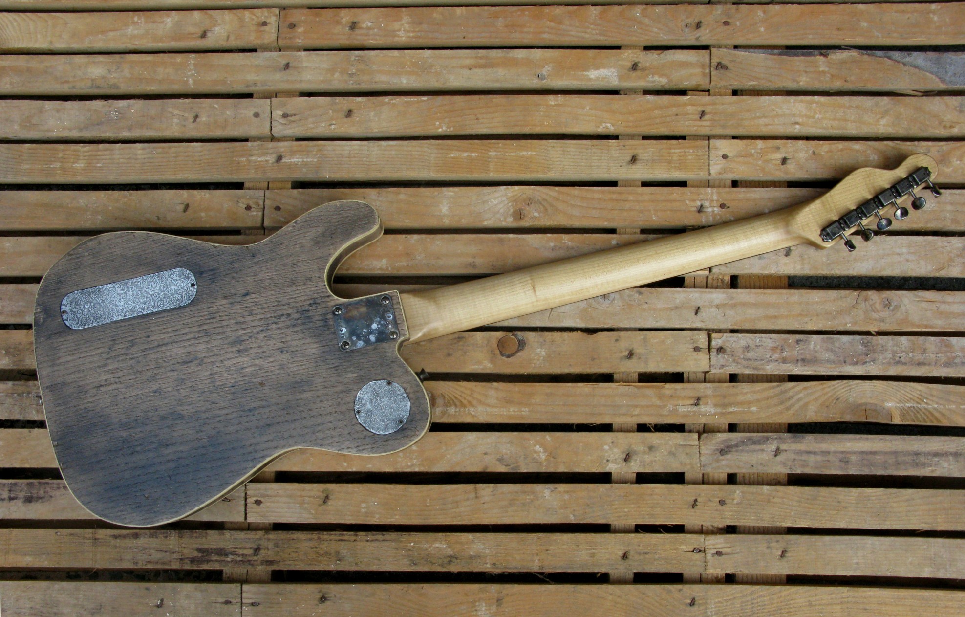 Retro di una chitarra elettrica baritono modello Telecaster con top ricavato da una vecchia cassetta di polvere da sparo