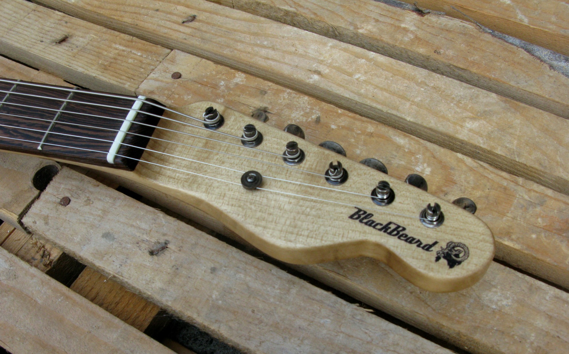 Paletta in acero di una chitarra elettrica baritono modello Telecaster con top ricavato da una vecchia cassetta di polvere da sparo