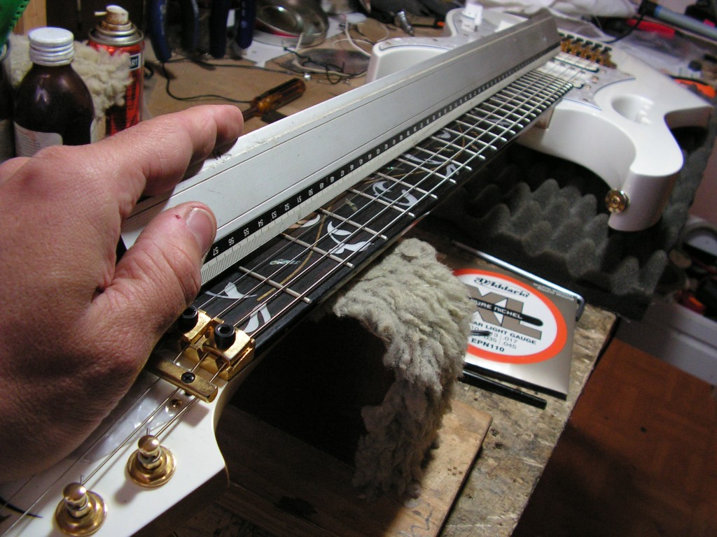 Operazione di rettifica tasti di una chitarra elettrica in seguito a ritastatura